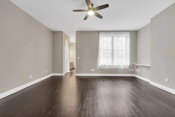 an empty room with wooden floor and windows