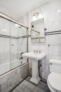 a bathroom with a sink a toilet and shower