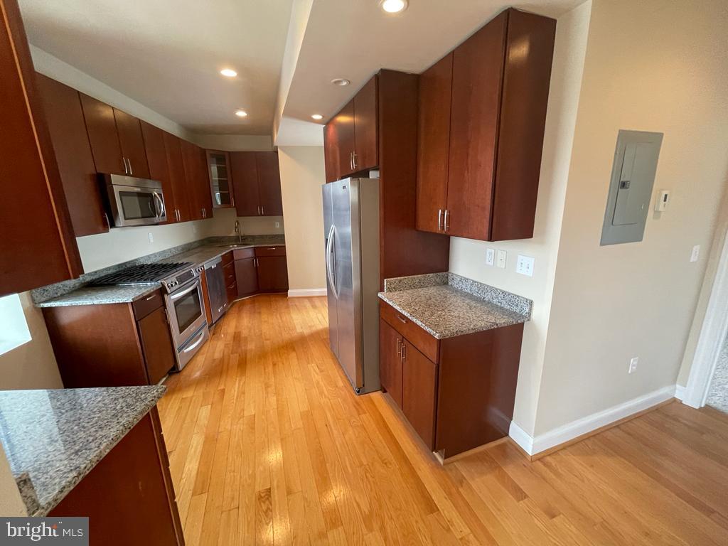 1033 Park Road Northwest, Unit 6 Washington, DC 20010 - Photo 4 of 38 a kitchen with stainless steel appliances granite countertop a refrigerator a stove and a wooden floors