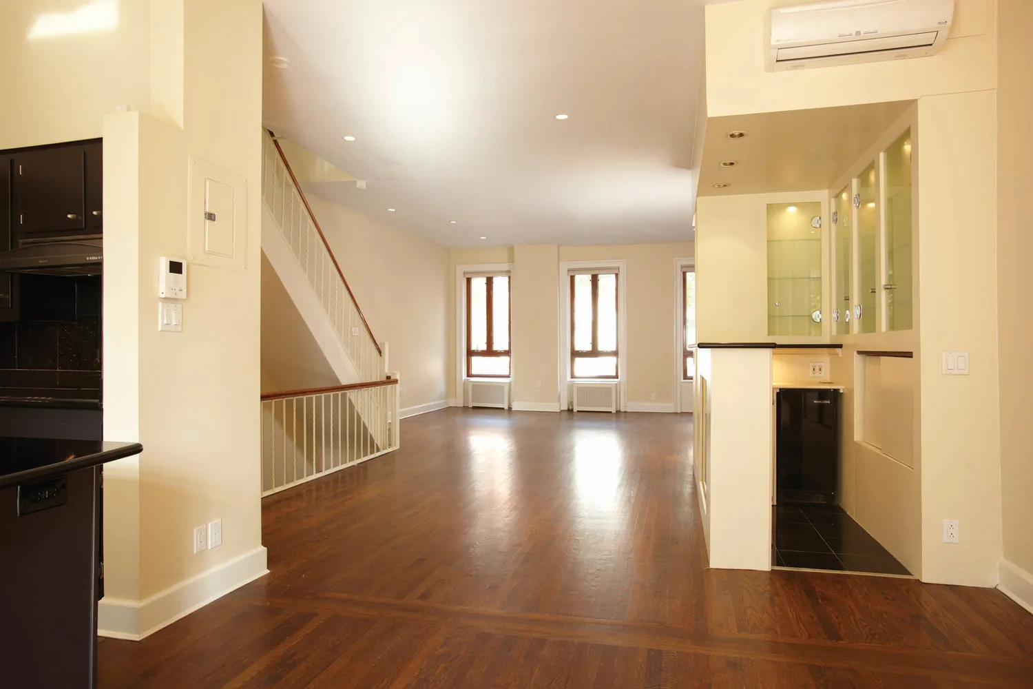 a view of a hallway with wooden floor and staircase
