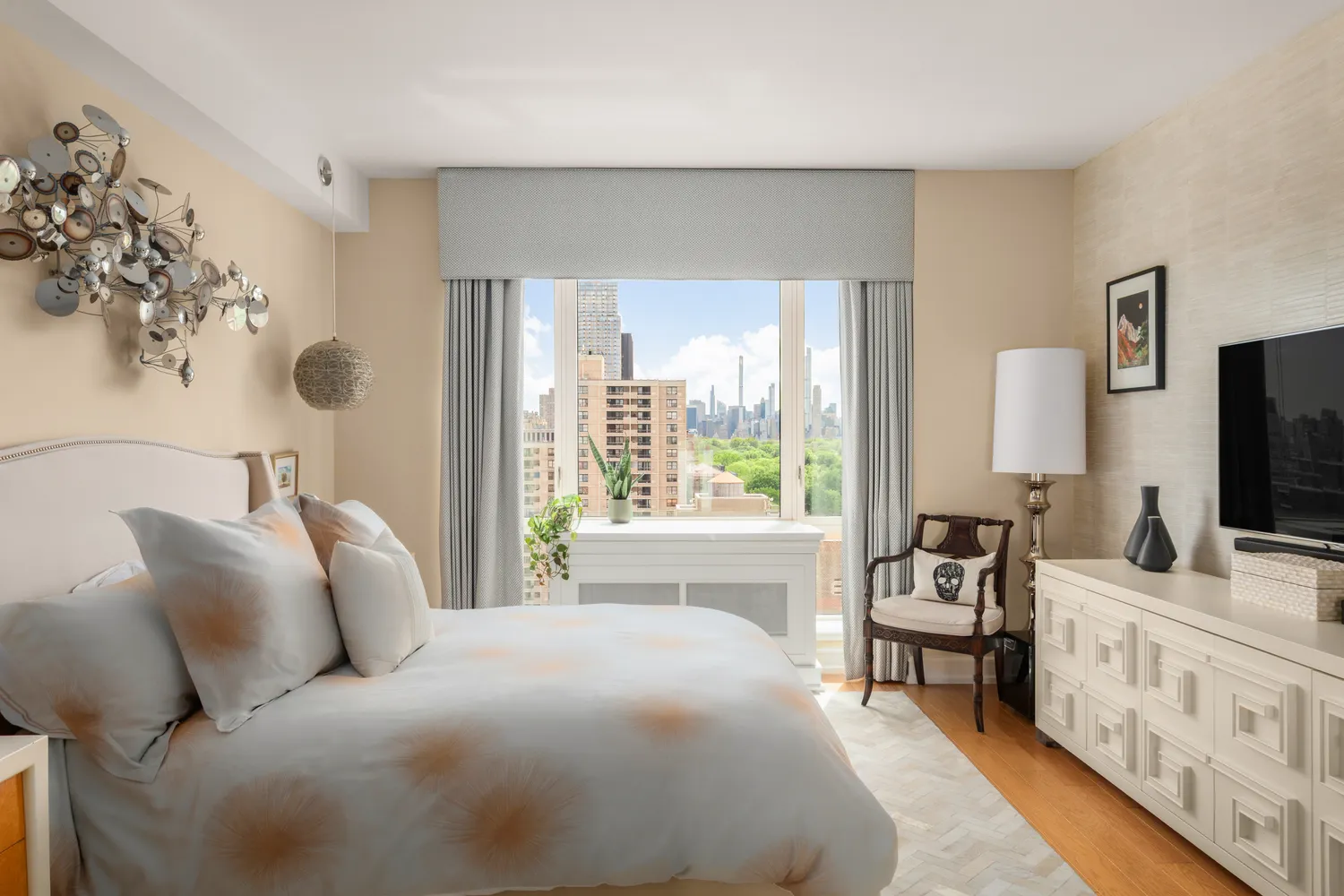 a bedroom with a bed and flat tv screen on the dresser