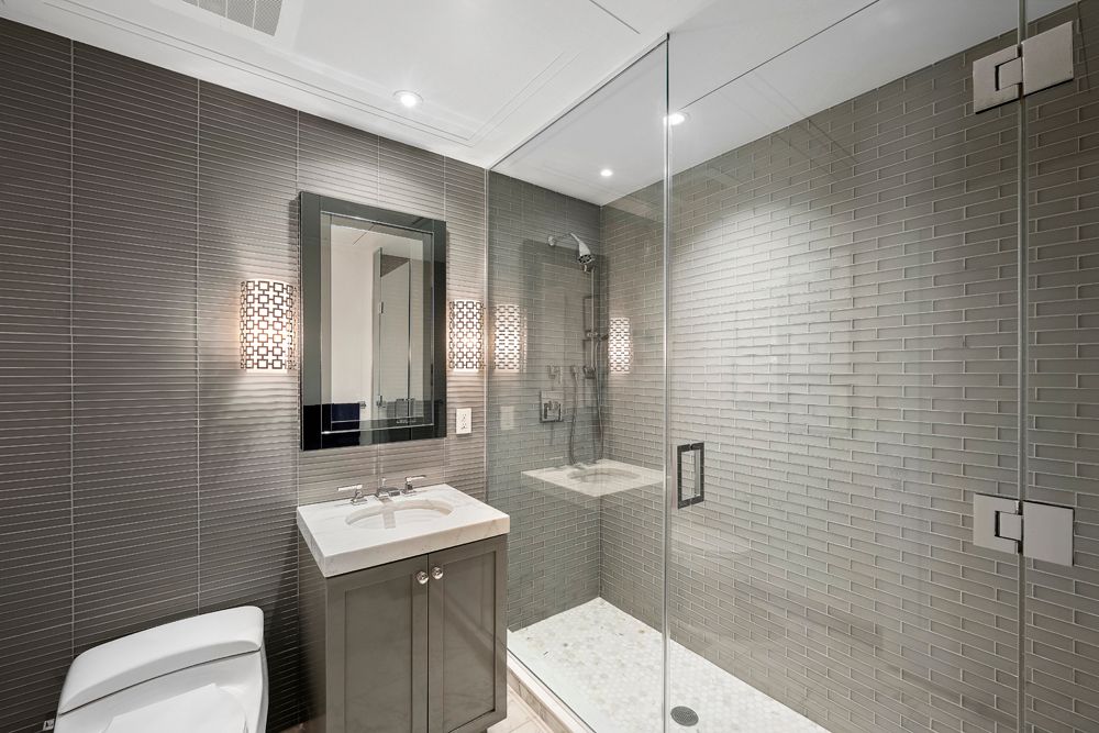 a bathroom with a sink shower and a mirror