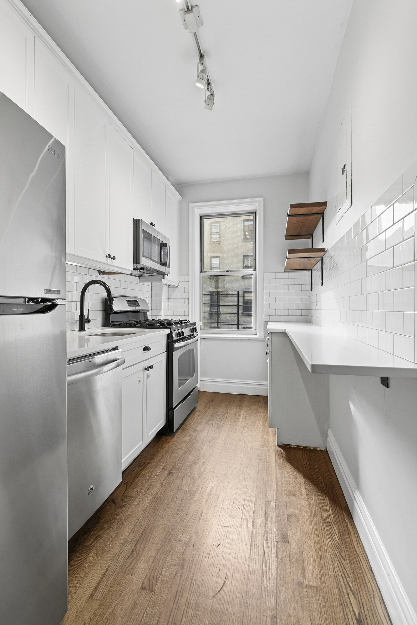 680 West 204th Street, Unit 3E Manhattan, NY 10034 - Photo 2 of 7 a kitchen with granite countertop a sink cabinets and stainless steel appliances