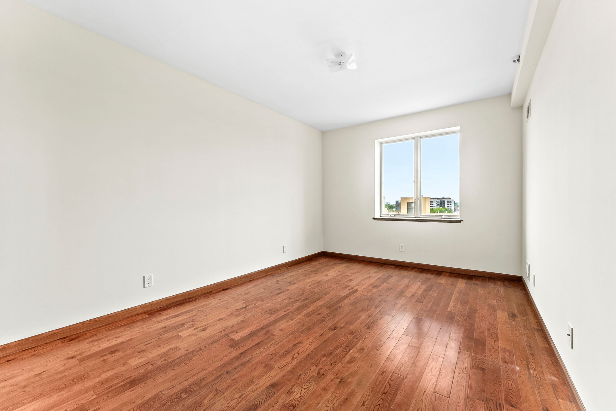 842 Ocean Parkway, Unit 8B Brooklyn, NY 11230 - Photo 8 of 14 an empty room with wooden floor and windows