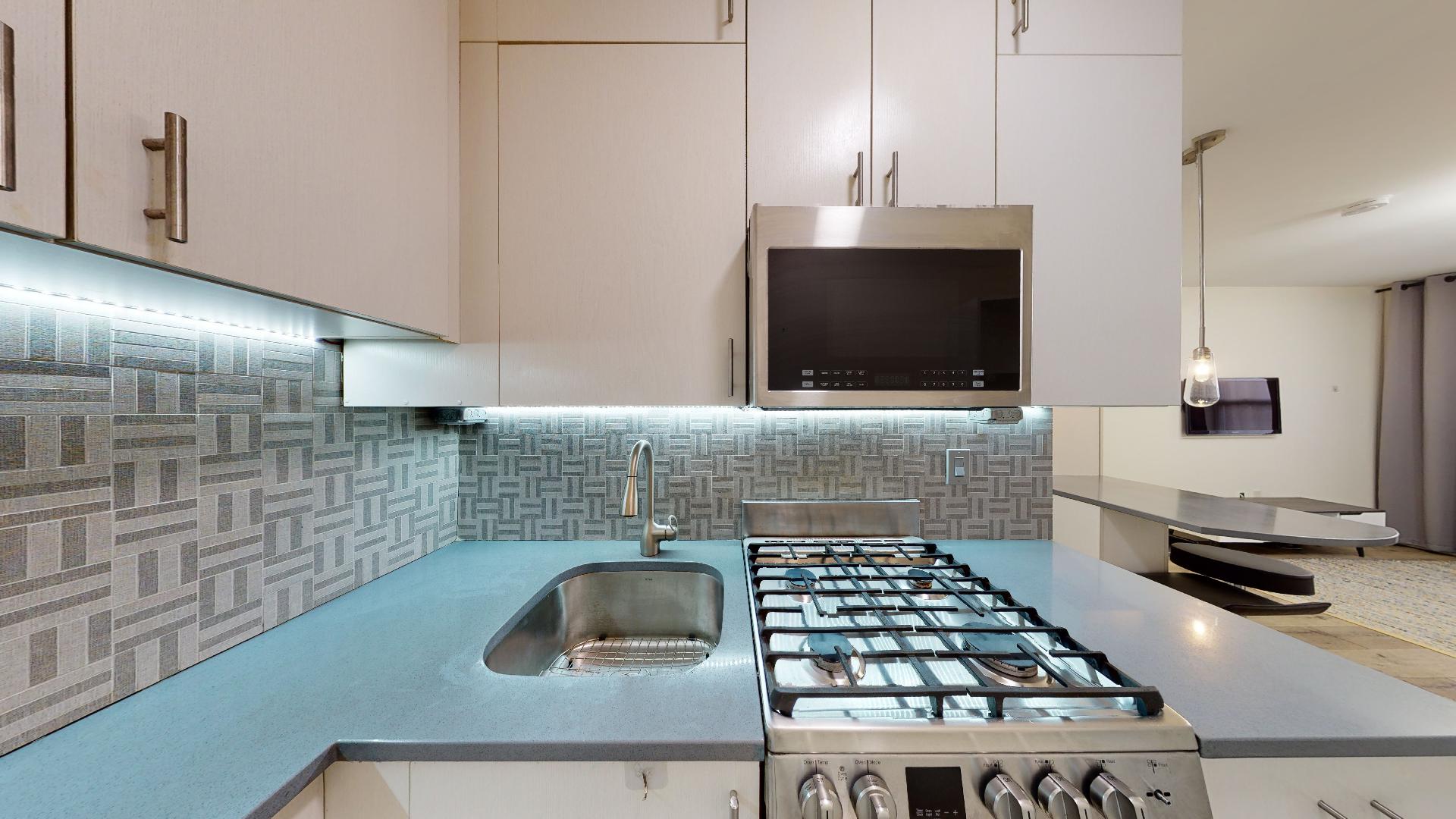 130 West 71st Street, Unit 1 Manhattan, NY 10023 - Photo 6 of 11 a kitchen with a sink a stove and a microwave oven