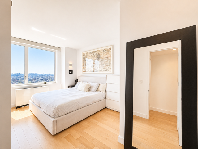 22 North 6th Street, Unit 23K Brooklyn, NY 11249 - Photo 5 of 11 a bedroom with a bed and a large window
