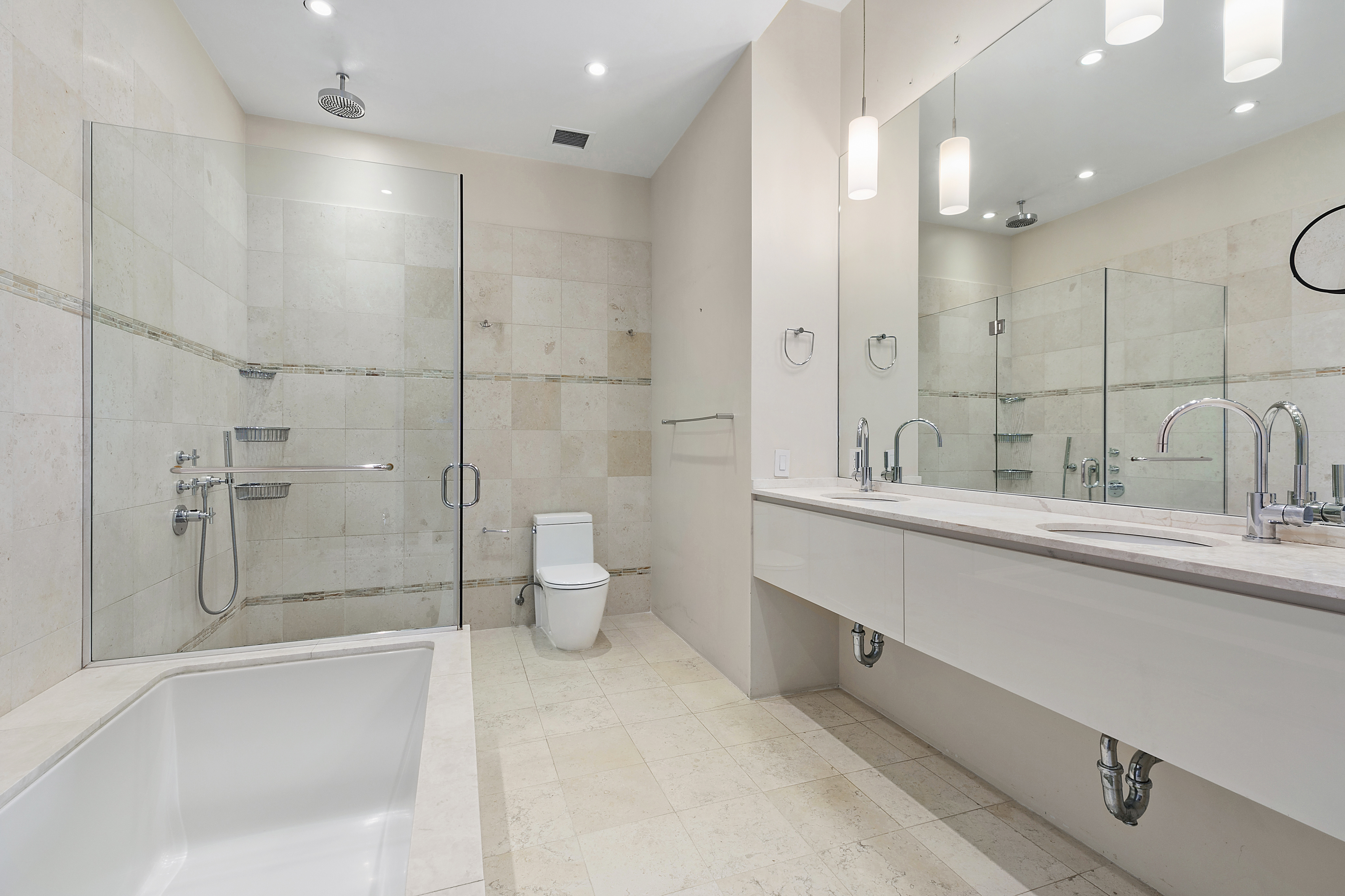 175 East Broadway, Unit 7A Manhattan, NY 10002 - Photo 7 of 9 a bathroom with a double vanity sink toilet and shower