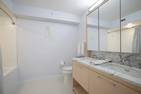 a bathroom with a granite countertop sink a toilet and a shower
