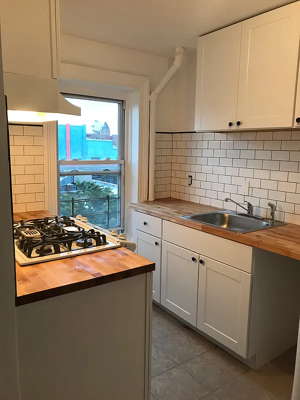 1379 Pacific Street, Unit 4 Brooklyn, NY 11216 - Photo 4 of 8 a kitchen with stainless steel appliances a sink and a cabinets