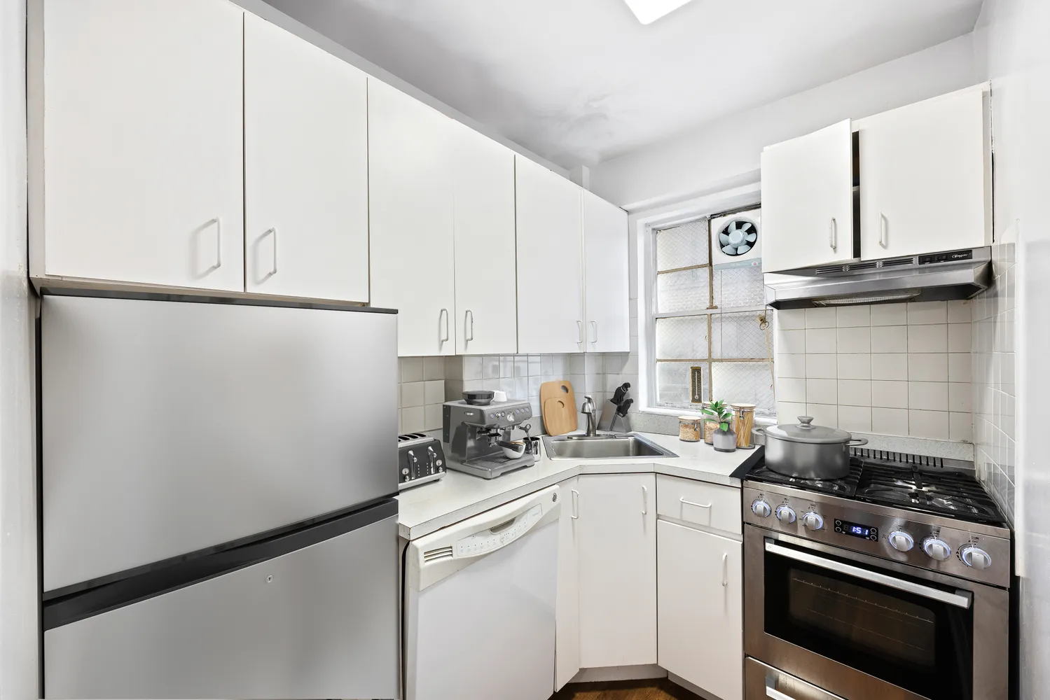 a kitchen with stainless steel appliances a sink stove and cabinets