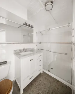 a bathroom with a granite countertop sink mirror vanity and toilet