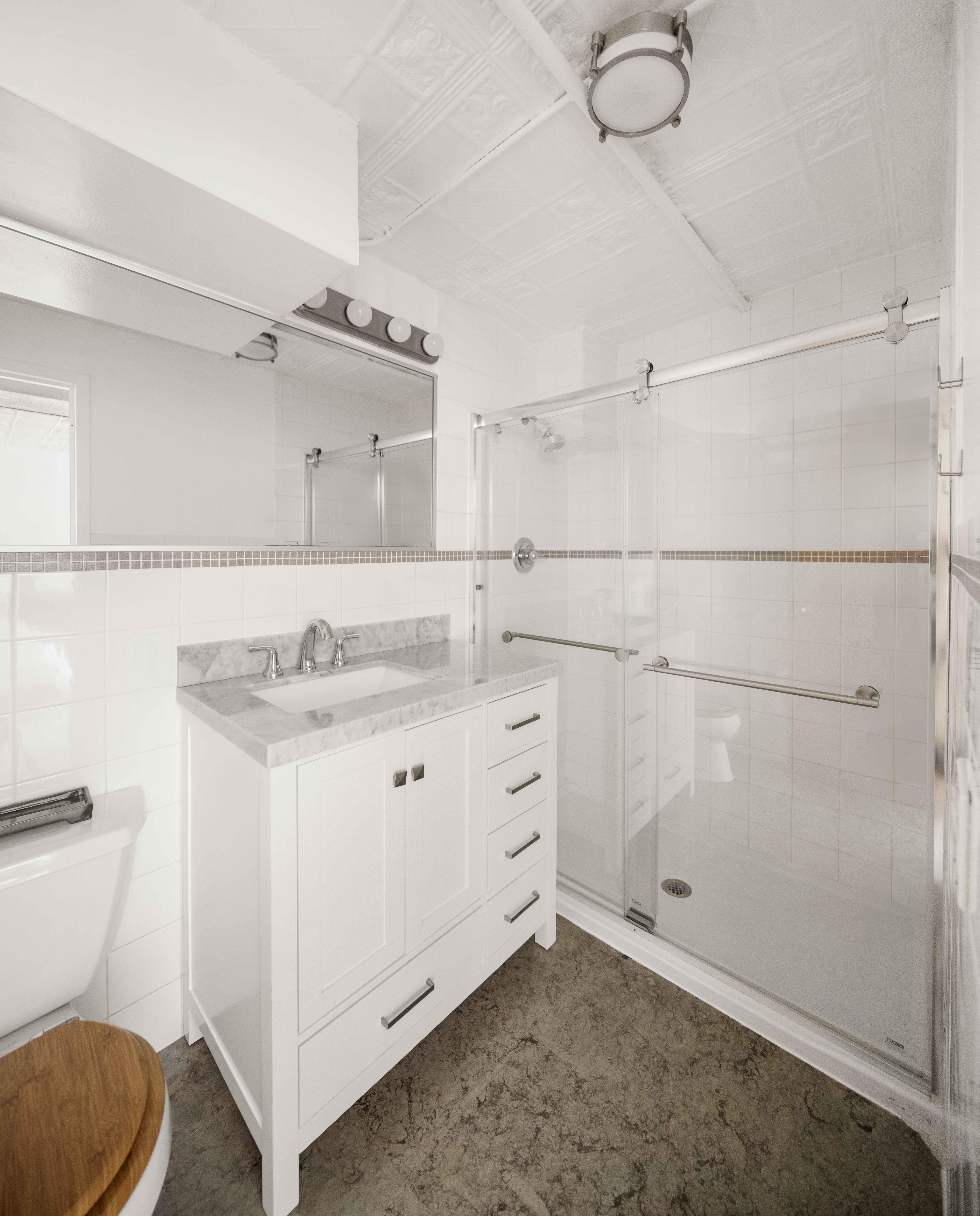 138 Broadway, Unit 1D Brooklyn, NY 11211 - Photo 7 of 9 a bathroom with a granite countertop sink mirror vanity and toilet