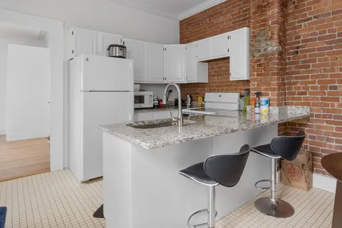 a kitchen with stainless steel appliances granite countertop a refrigerator and a stove top oven