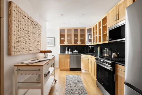 a kitchen with stainless steel appliances kitchen island granite countertop a stove and a microwave