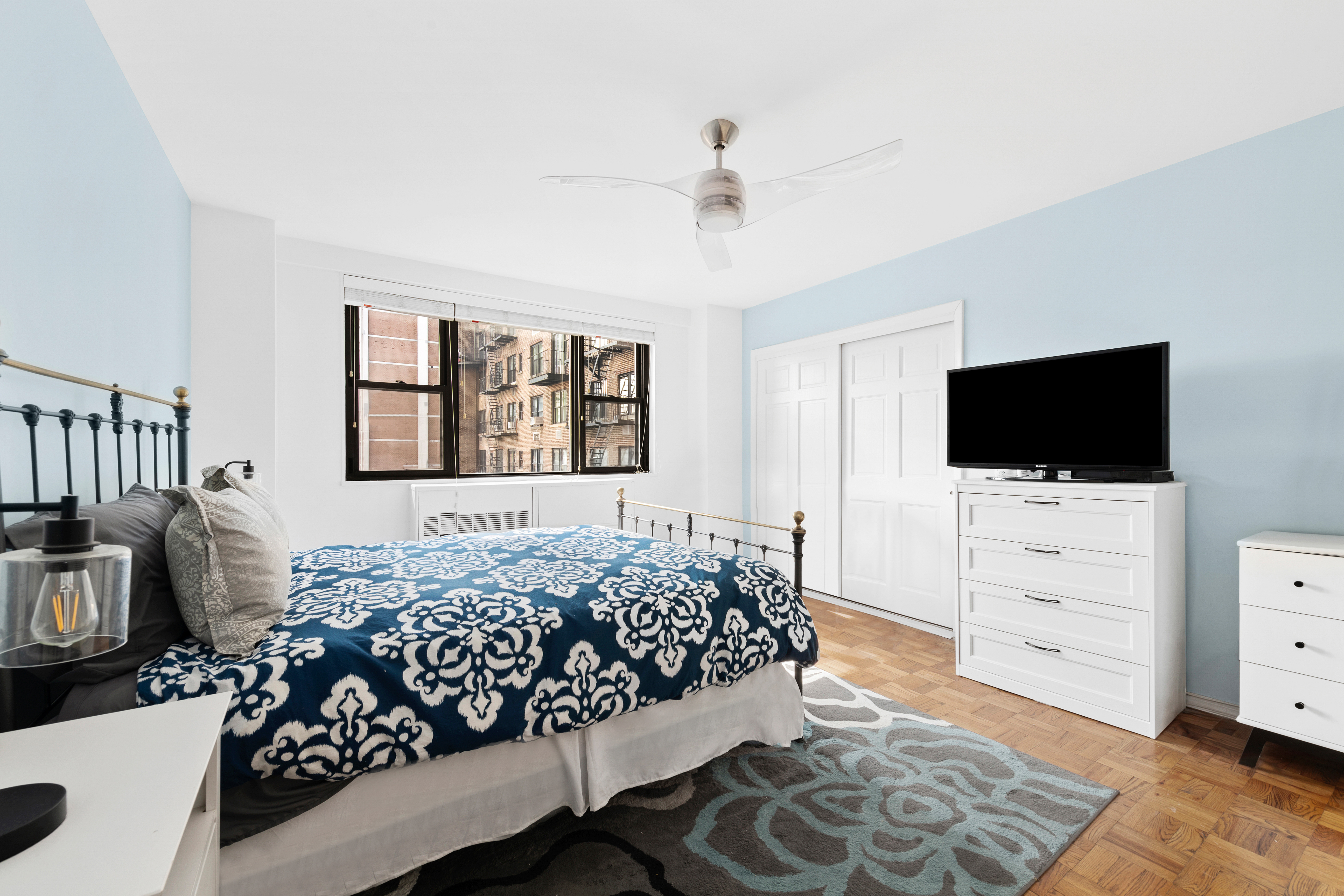 315 East 72nd Street, Unit 15M Manhattan, NY 10021 - Photo 9 of 18 a bedroom with a bed television on dresser and a dresser