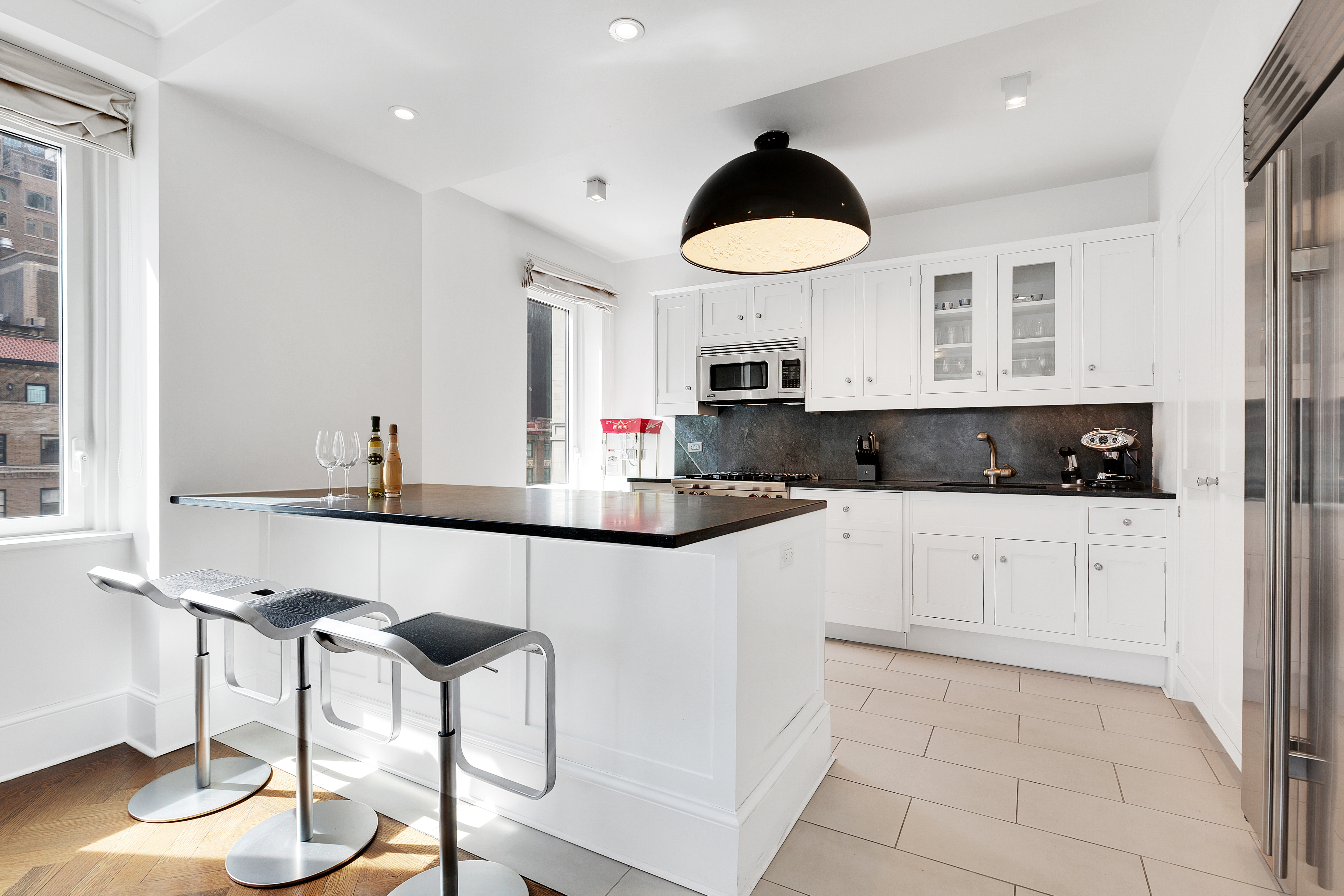 530 Park Avenue, Unit 17A Manhattan, NY 10065 - Photo 8 of 22 a kitchen with stainless steel appliances a refrigerator a stove a sink and white cabinets with wooden floor