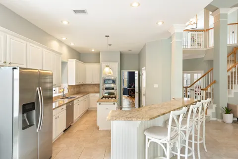 a kitchen with stainless steel appliances kitchen island granite countertop a refrigerator and microwave