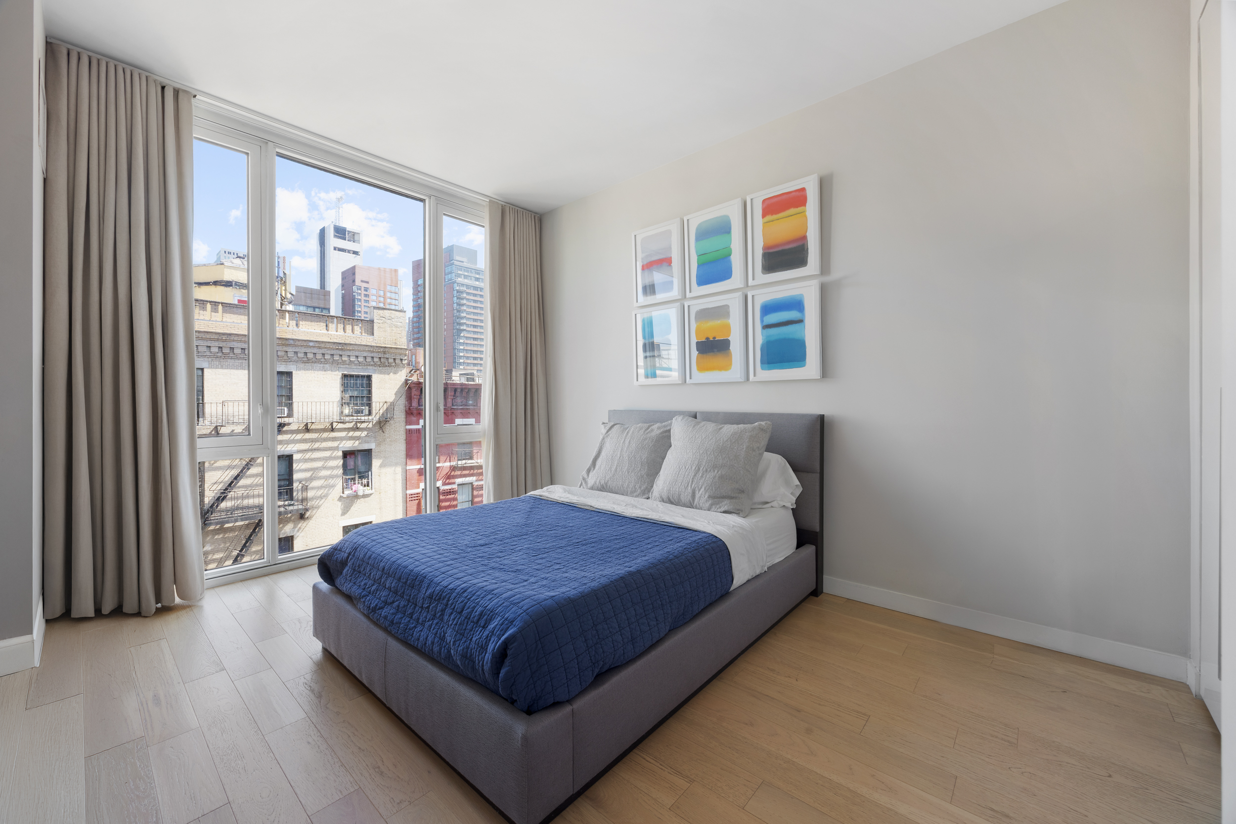 540 West 49th Street, Unit PH1N Manhattan, NY 10019 - Photo 12 of 18 a large bed sitting in a bedroom next to a window