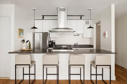 a kitchen with stainless steel appliances kitchen island granite countertop a table and chairs