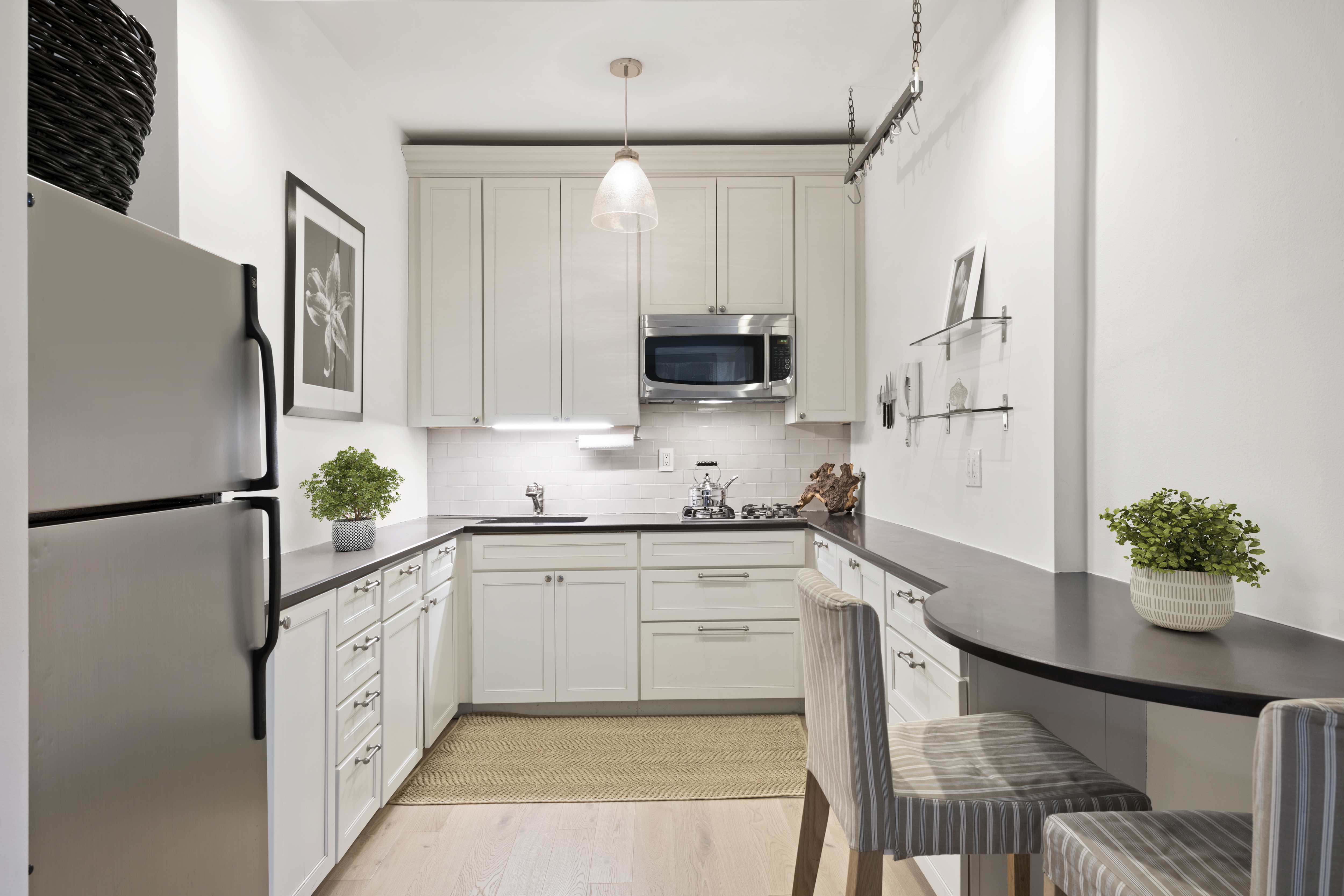 201 East 21st Street, Unit 12M Manhattan, NY 10010 - Photo 4 of 10 a kitchen with stainless steel appliances white cabinets and a refrigerator