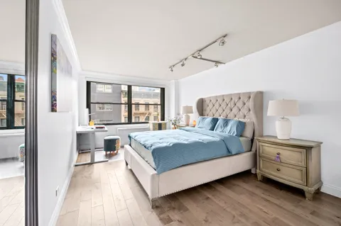 a bedroom with a bed and a large window with outer view