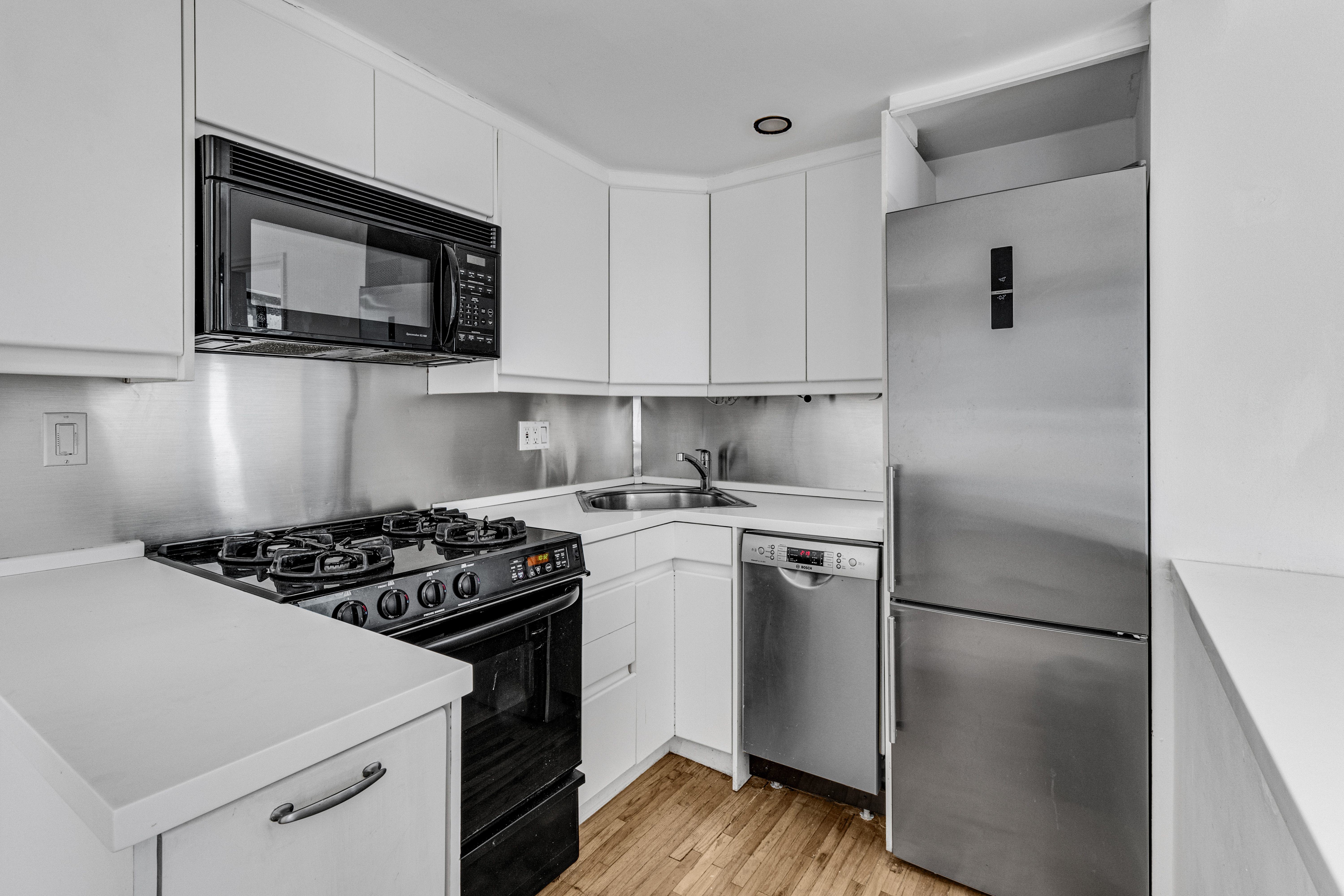 207 East 21st Street, Unit 6B Manhattan, NY 10010 - Photo 4 of 11 a kitchen with a stove microwave and refrigerator
