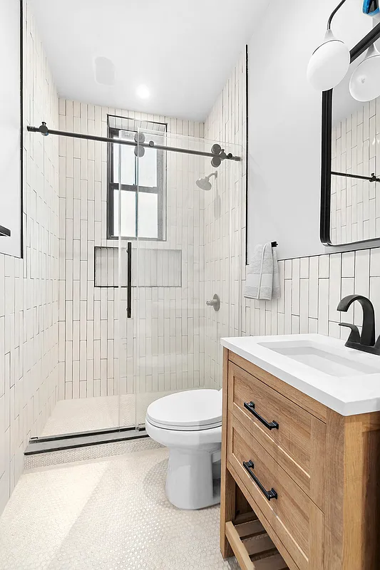 506 Woodward Avenue, Unit 1R Queens, NY 11385 - Photo 6 of 10 a bathroom with a granite countertop sink a toilet and shower