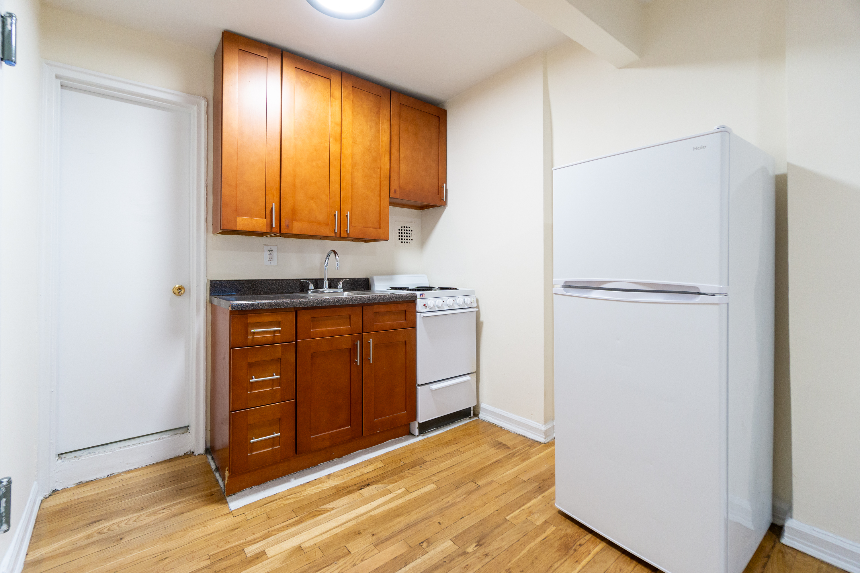 319 East 5th Street, Unit B Manhattan, NY 10003 - Photo 9 of 17 a kitchen with a refrigerator sink and cabinets