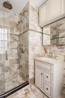 a bathroom with a granite countertop sink a toilet and shower