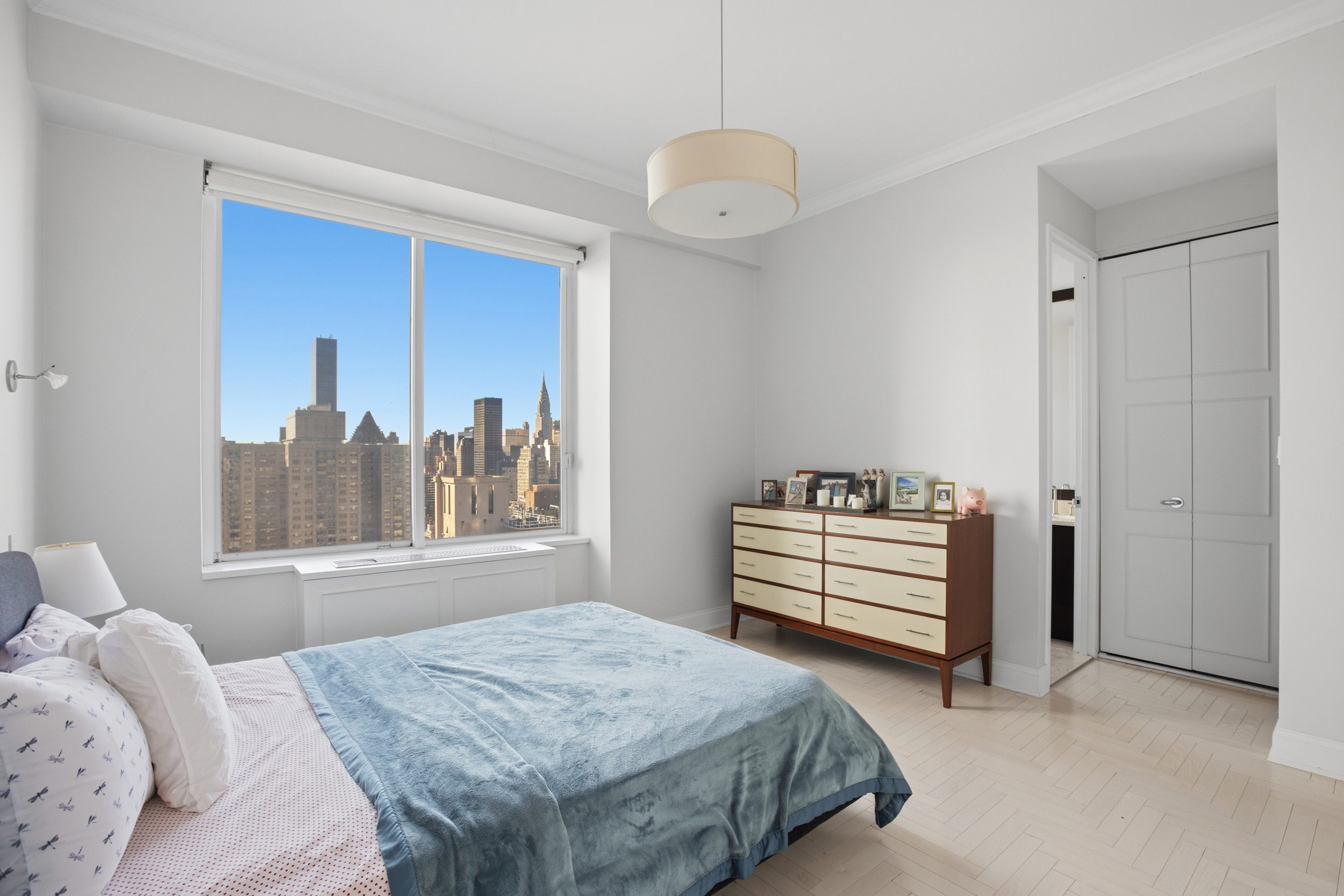 418 East 59th Street, Unit PHA Manhattan, NY 10022 - Photo 8 of 17 a bedroom with a bed and a dresser