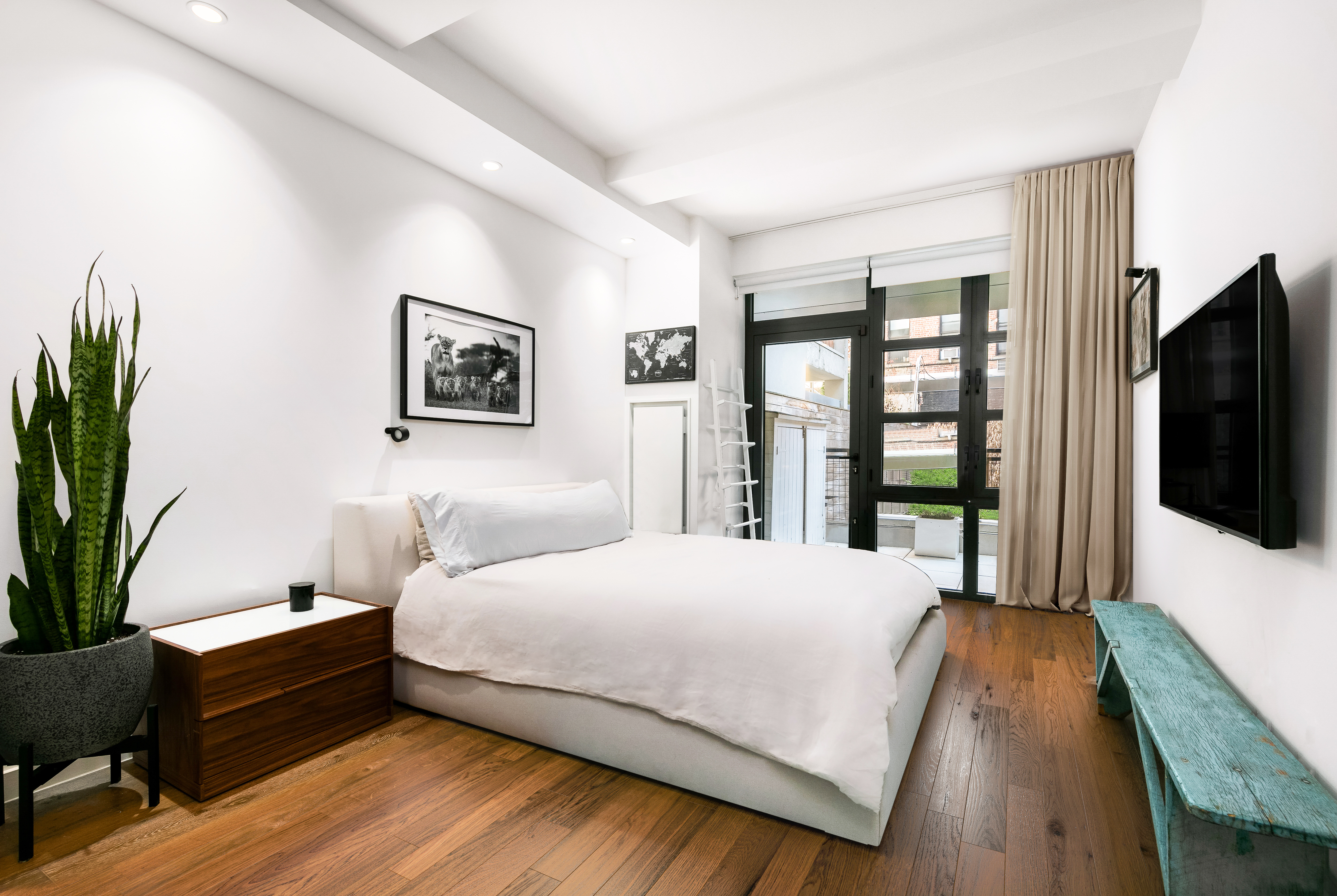 64 East 1st Street, Unit TH1 Manhattan, NY 10003 - Photo 10 of 15 a bedroom with a bed and a flat screen tv