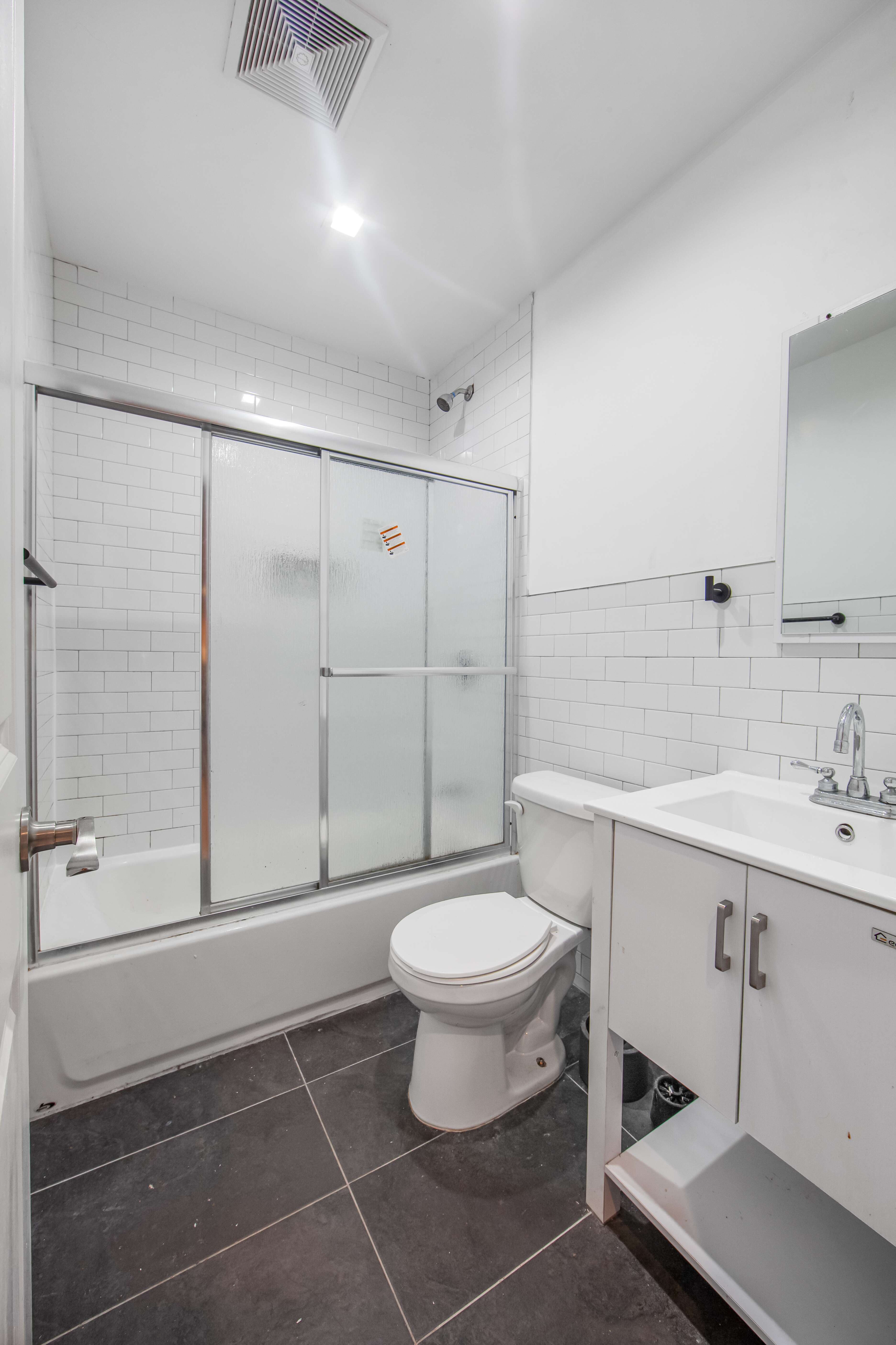 311 East 119th Street, Unit 3 Manhattan, NY 10035 - Photo 1 of 1 a bathroom with a toilet sink and a shower