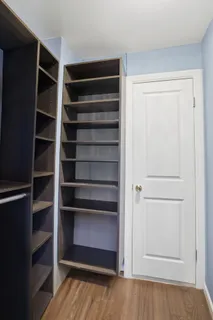 a view of walk in closet with empty racks