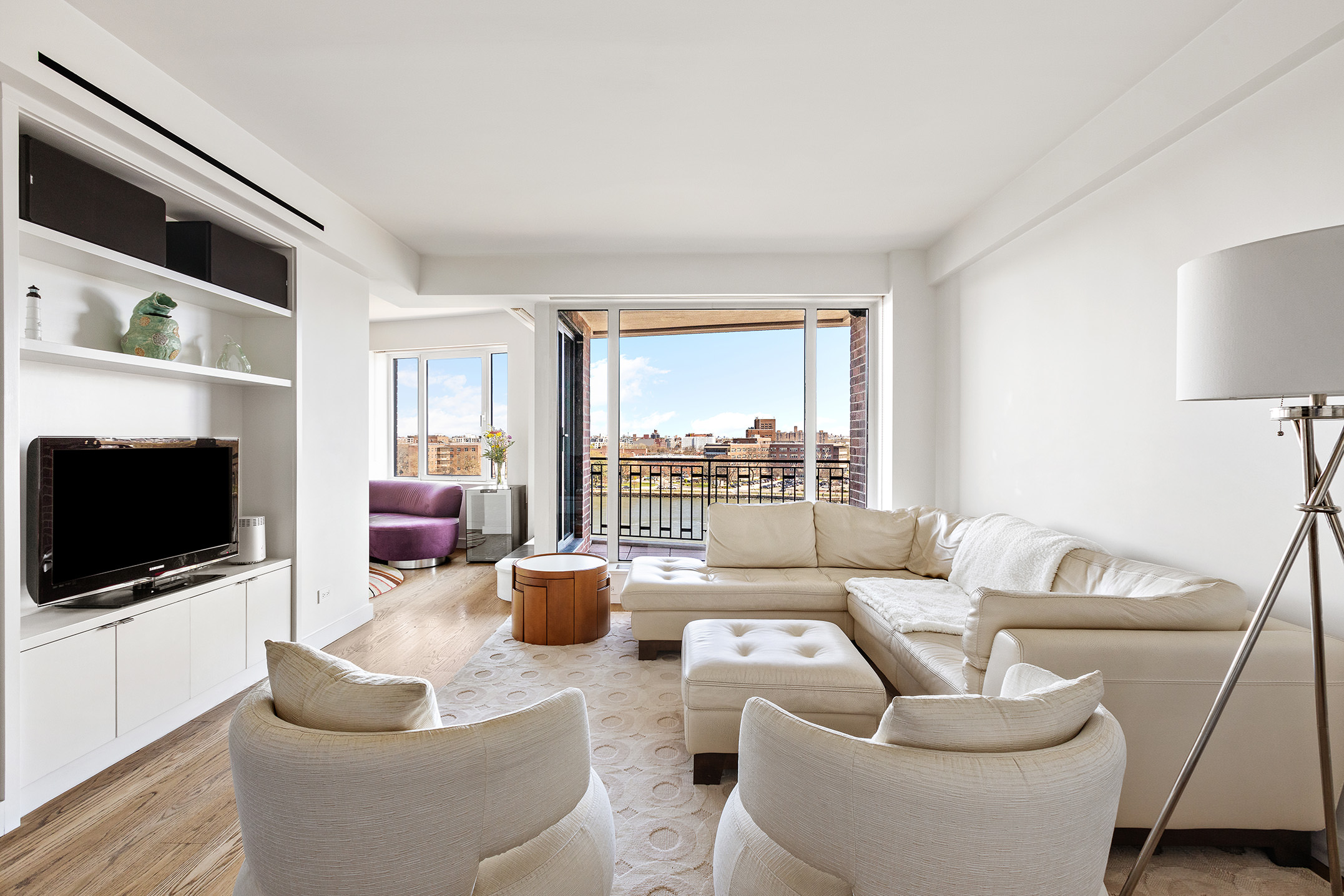 a living room with furniture a flat screen tv and a large window