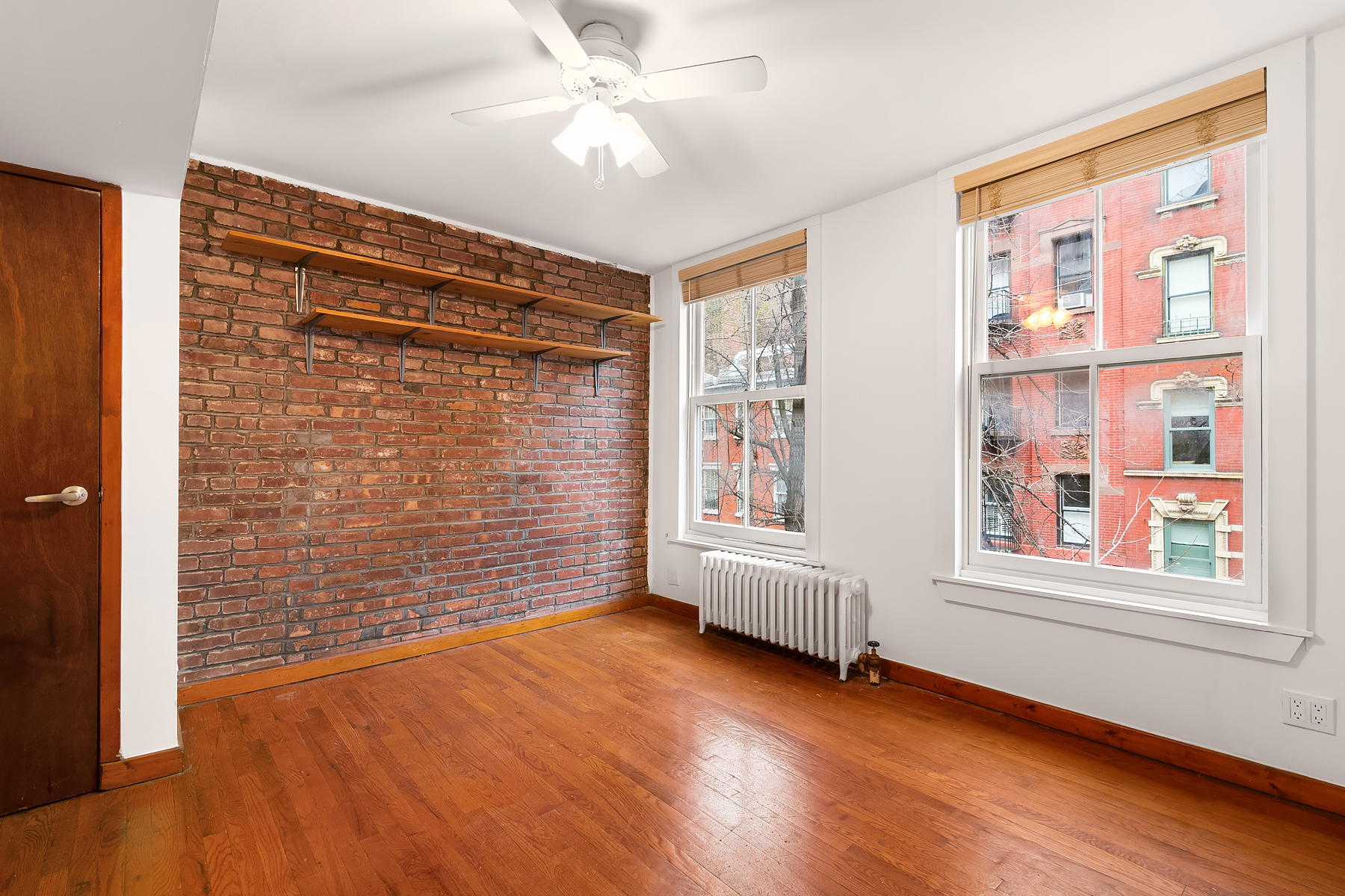 49 Perry Street, Unit 2E Manhattan, NY 10014 - Photo 1 of 3 a view of an empty room with a window and wooden floor