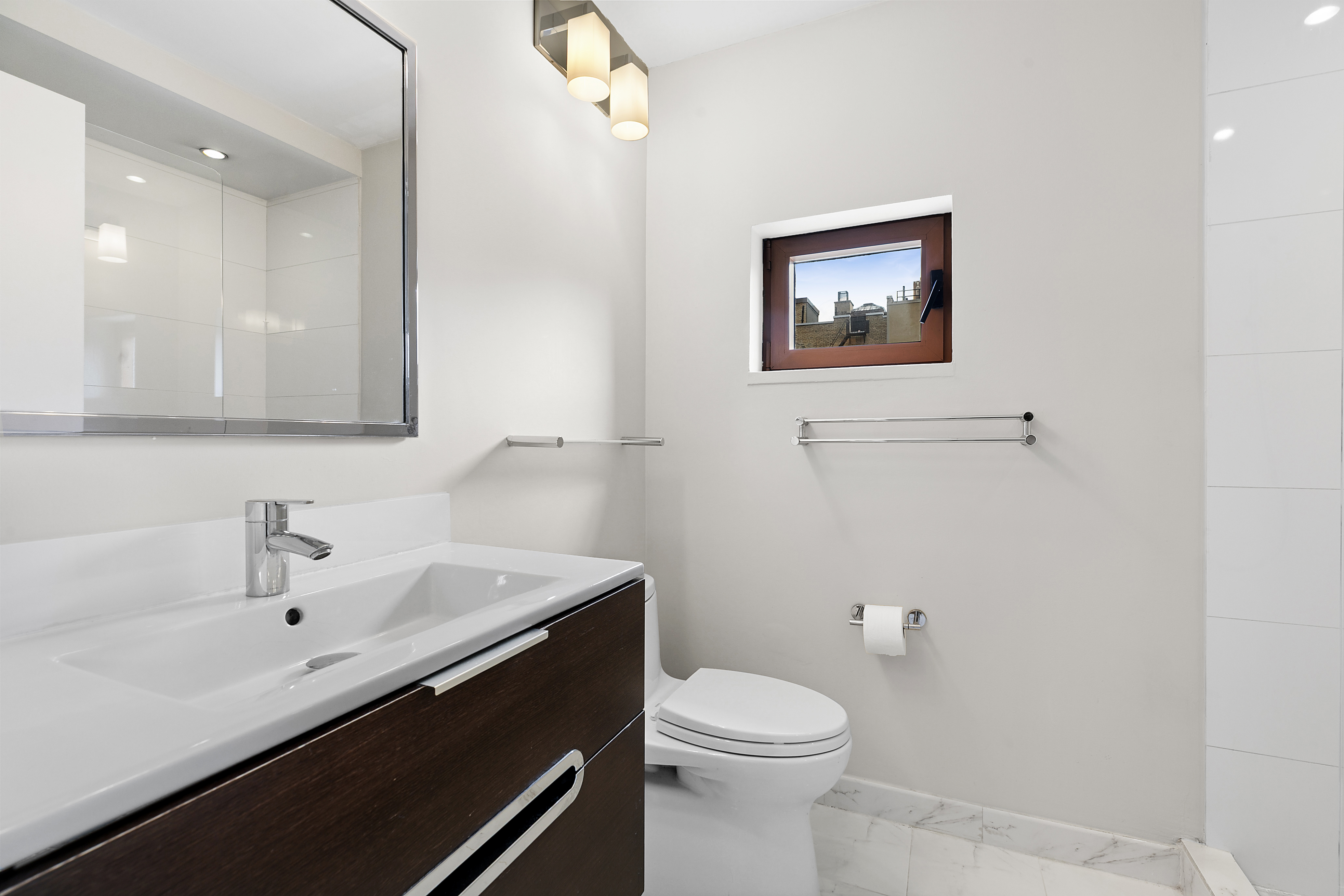 270 West 17th Street, Unit 4L Manhattan, NY 10011 - Photo 7 of 11 a bathroom with a toilet sink and mirror