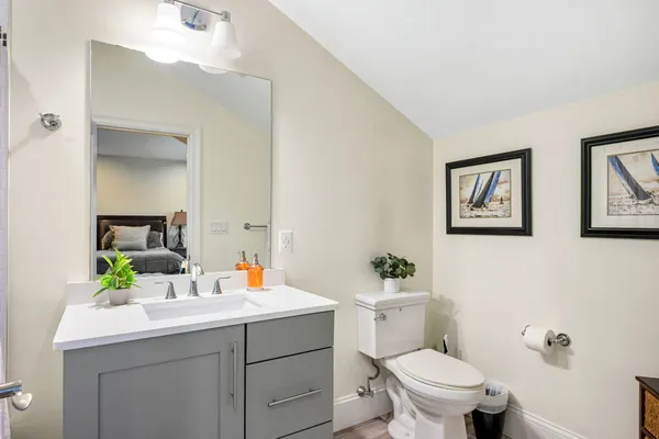 a bathroom with a sink mirror vanity and toilet