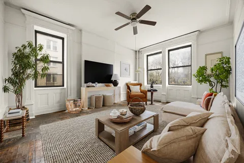 a living room with furniture a flat screen tv and a large window