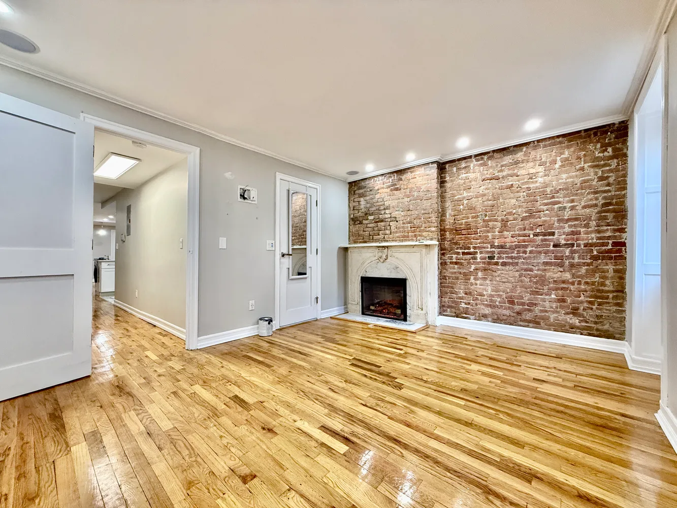 a view of empty room with fireplace and wooden floor