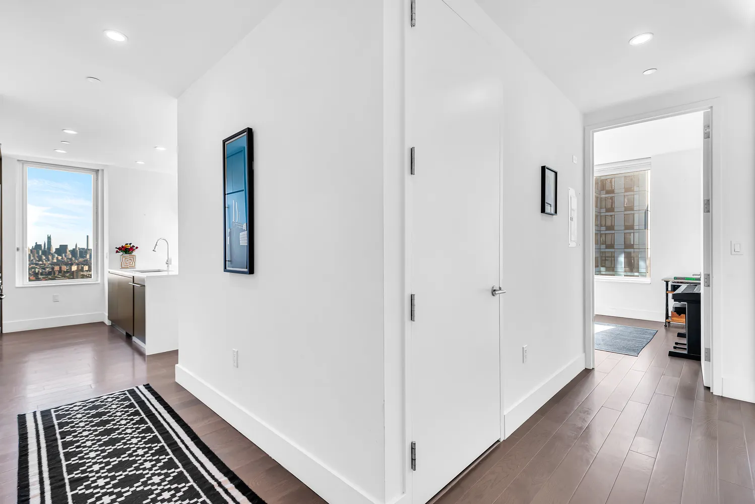 a view of a hallway with wooden floor and furniture