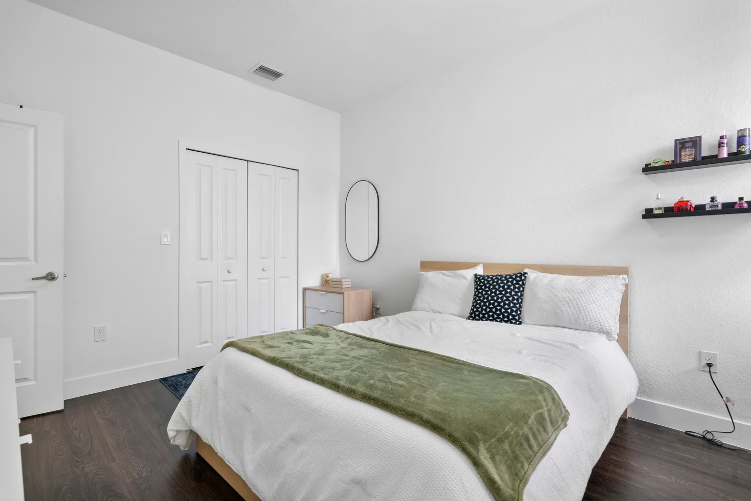 a bedroom with a bed and wooden floor