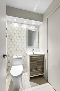 a bathroom with a toilet sink and mirror