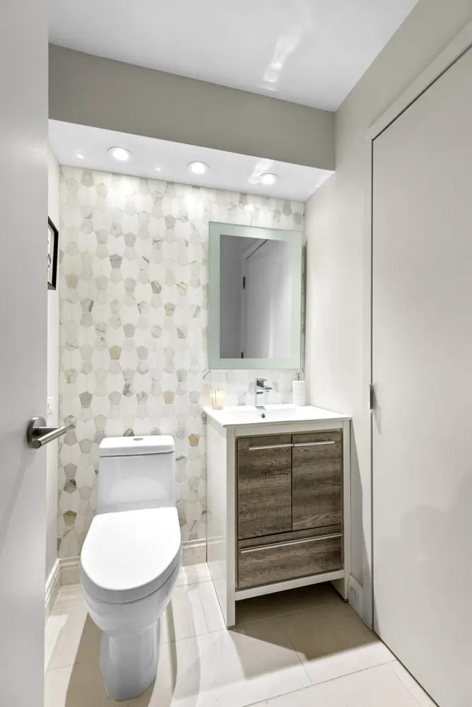 a bathroom with a toilet sink and mirror