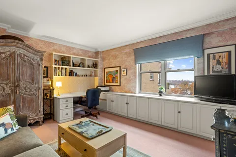 a living room with furniture a flat screen tv and a window