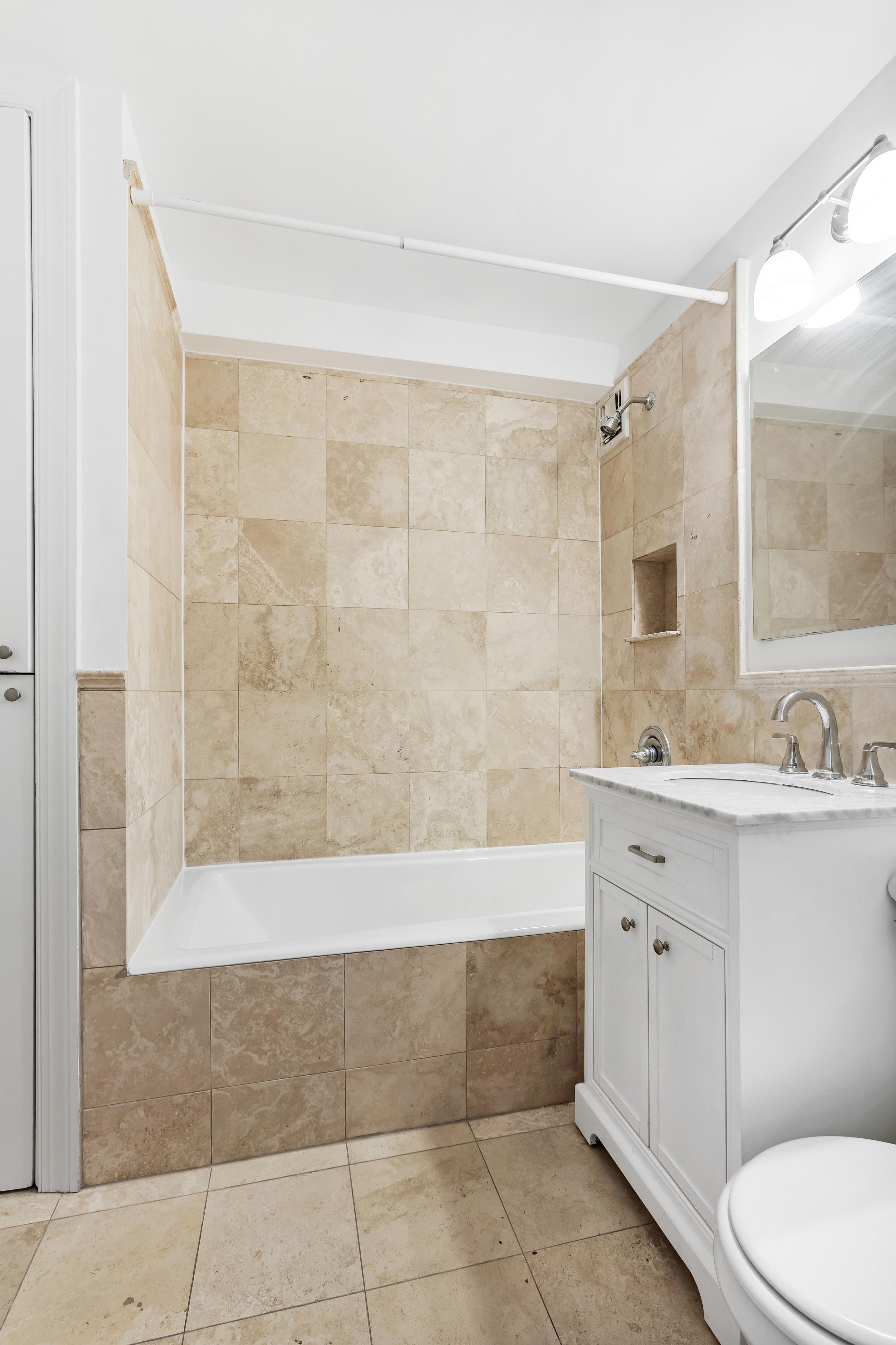333 East 34th Street, Unit 14D Manhattan, NY 10016 - Photo 7 of 11 a bathroom with a bathtub shower sink mirror and toilet