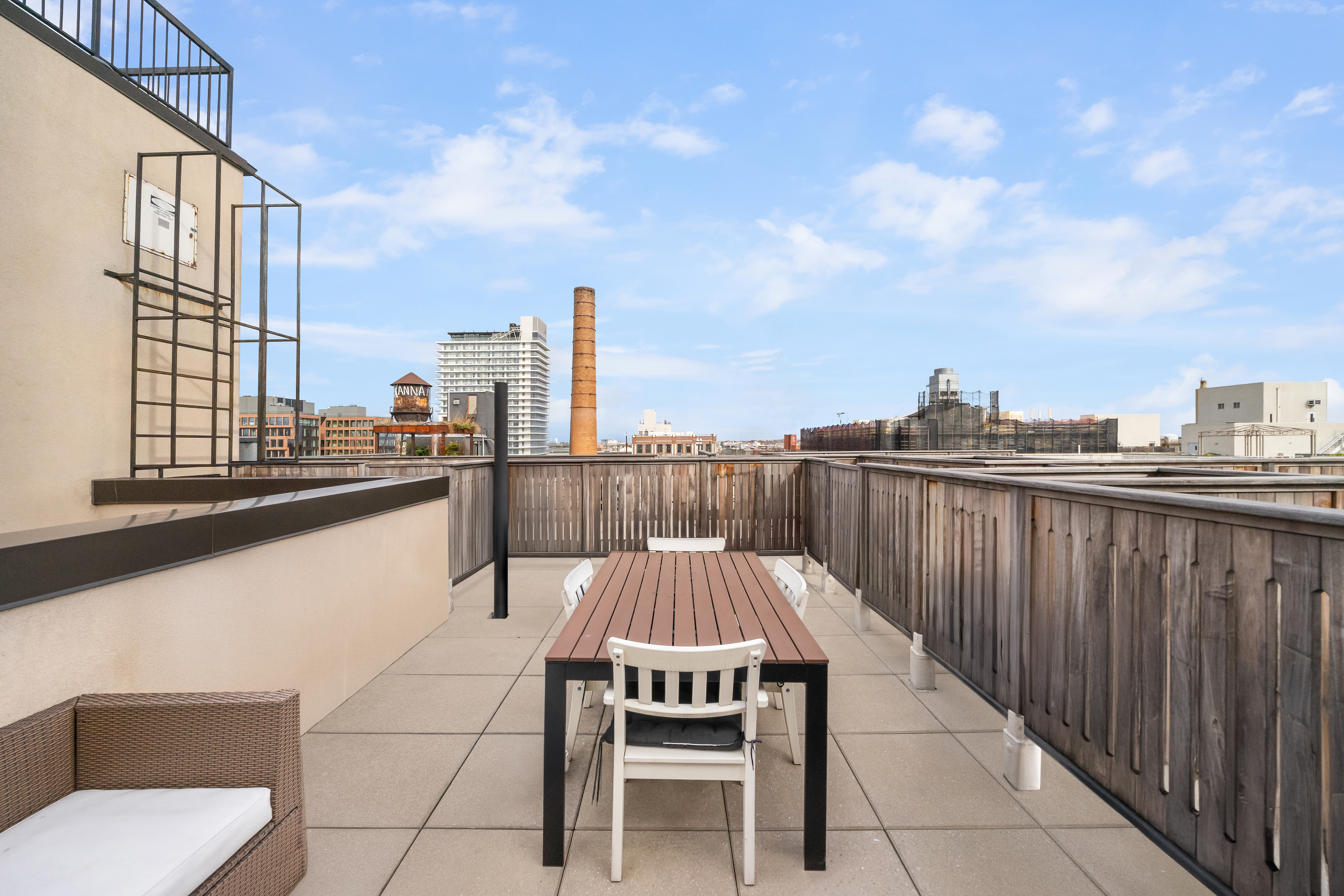 70 Berry Street, Unit 5G Brooklyn, NY 11249 - Photo 9 of 10 a view of a roof deck with a barbeque and wooden stairs