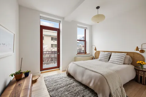 a bedroom with a bed and a large window