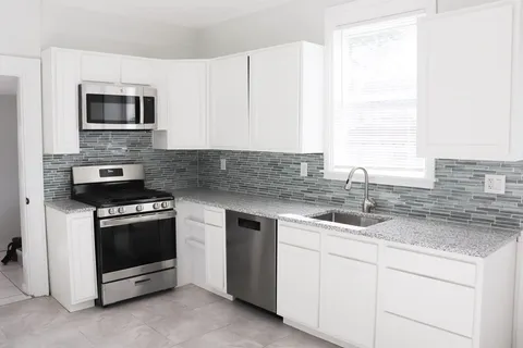 a kitchen with stainless steel appliances granite countertop a sink and a microwave