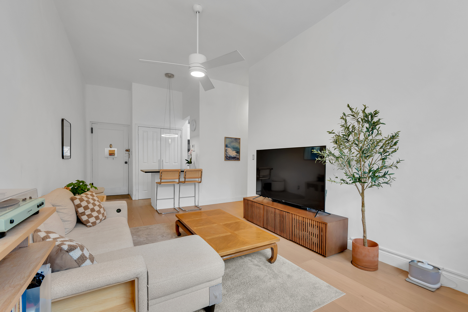 244 East 60th Street, Unit 3B Manhattan, NY 10022 - Photo 2 of 6 a living room with furniture and a flat screen tv
