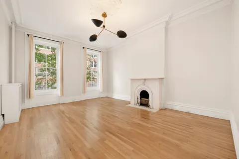 an empty room with windows and fireplace